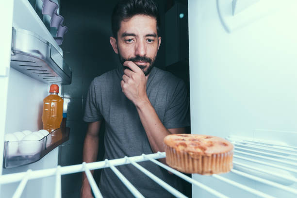 istock Hungry man opens the refrigerator at night 872919696