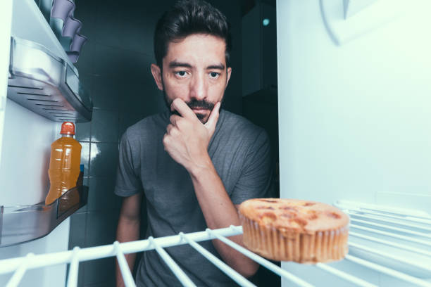 istock Hungry man opens the refrigerator at night 872919842