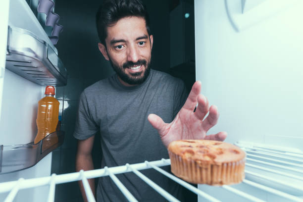 istock Hungry man opens the refrigerator at night 872919898