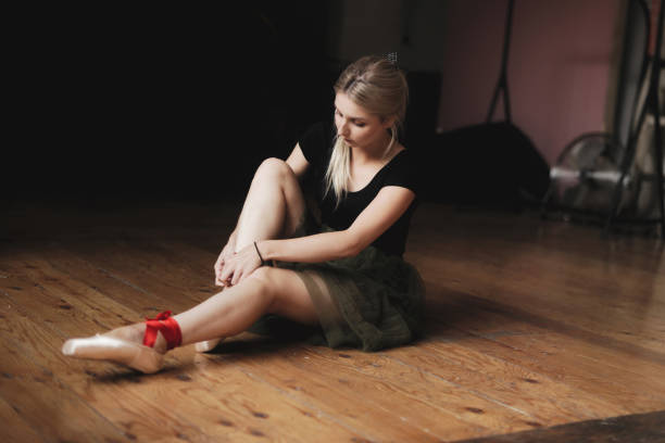 istock Beautiful ballerina sitting on floor 872930724