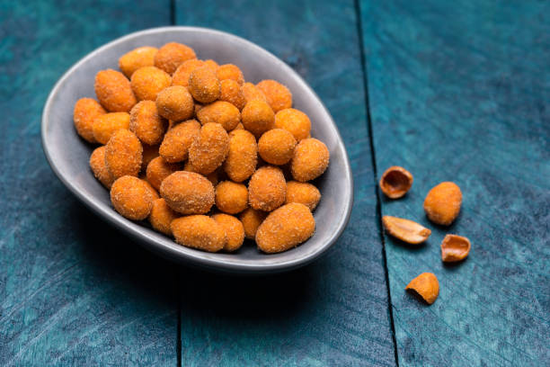 istock Peanuts in batter on petrol wood in bowl 872931064