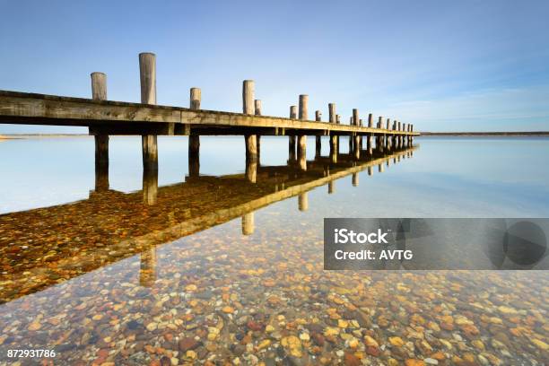 Calm Clear Lake With Wooden Pier Stock Photo - Download Image Now - Atmosphere, Beach, Boardwalk