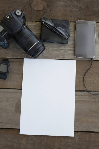 istock Digital camera, wallet, spectacles, smartwatch, mobile phone and blank paper on wooden surface 872934470