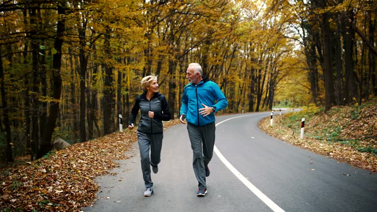 Senior couple jogging in a forest.