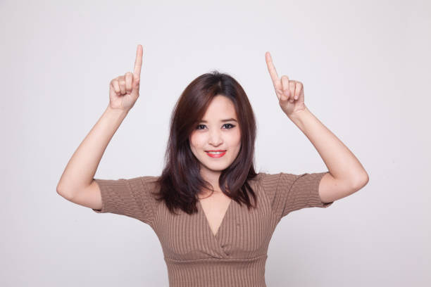 istock Young Asian woman point to blank space. 872934962