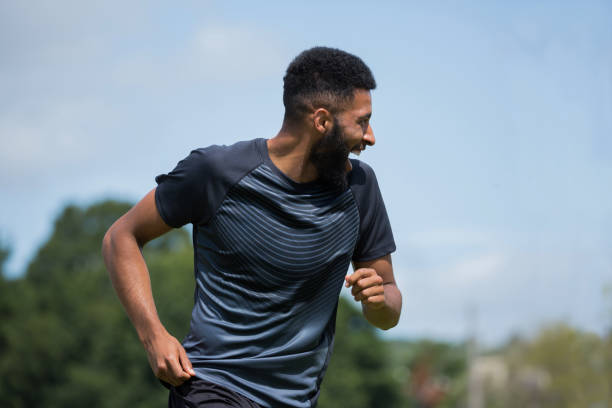 istock Smiling player playing football in the ground 872942624