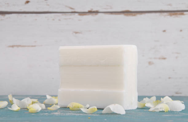 istock Soap and rose petals on weathered background 872946042