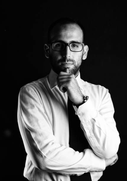istock Stylish handsome bearded man with glasses in trendy suit on black background 872953400