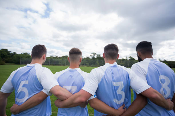 istock Football player standing together with arm around 872961478