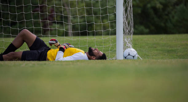 istock Goalkeeper relaxing near goalpost 872965926