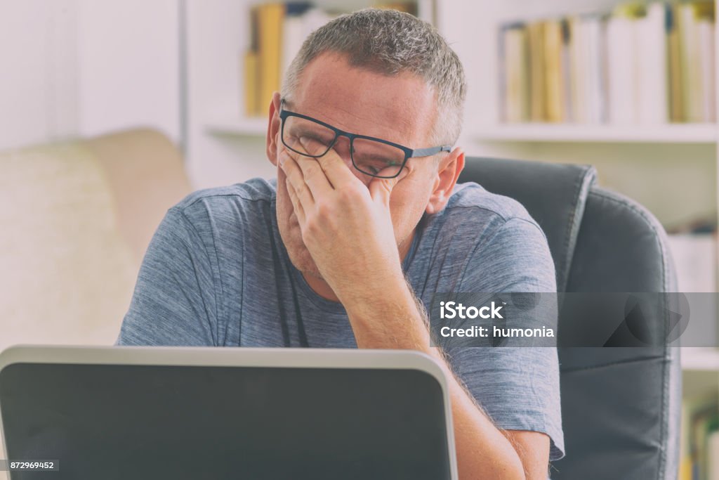 Homme fatigué pigiste frottant ses yeux - Photo de Fatigué libre de droits