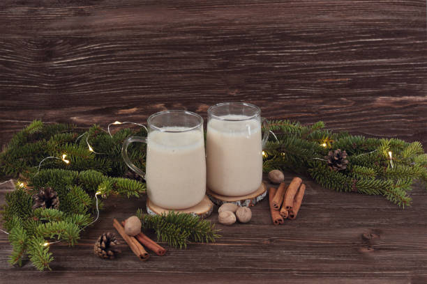 istock Christmas drink eggnog with nutmeg, cinnamon, Christmas tree, pine cones, on a wooden background 872969744