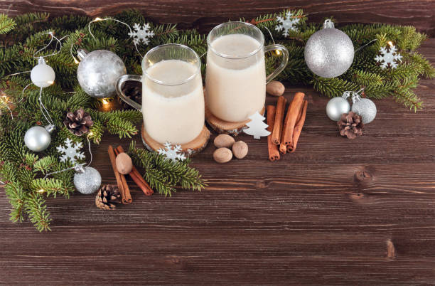 istock Christmas drink eggnog with nutmeg, cinnamon, Christmas tree, pine cones, on a wooden background 872969886