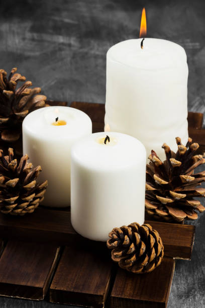 brennende kerzen und weihnachten attribute auf einem dunklen hintergrund - candle heat gold burning stock-fotos und bilder