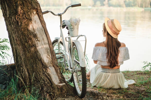 istock Romantic girl with a bicycle on the river bank 872984448