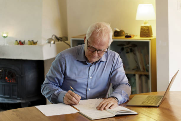 istock Working businessman sitting at a desk with a computer in a cozy home interiour making calculations 872994414