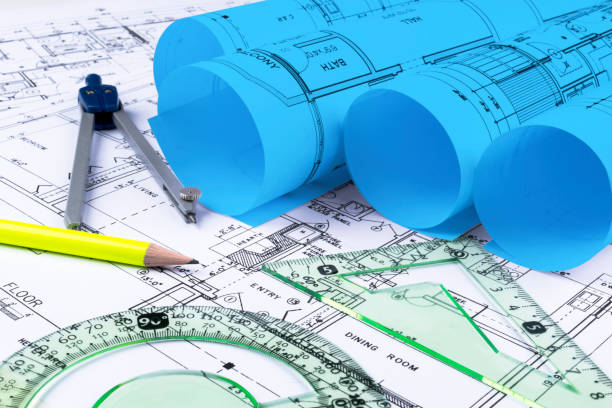 istock Architectural blueprints and blueprint rolls and a drawing instruments on the worktable. Drawing compass, plans. Civil Engineering, Construction background. 873008726