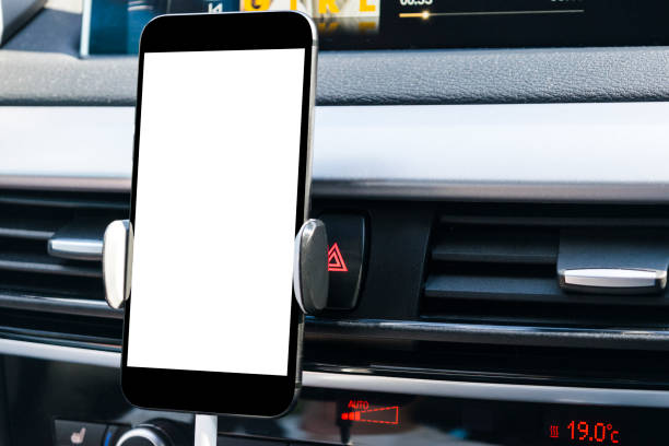 istock Smartphone in a car use for Navigate or GPS. Driving a car with Smartphone in holder. Mobile phone with isolatede white screen. Blank empty screen. copy space. Empty space for text. modern car interior details. 873008752