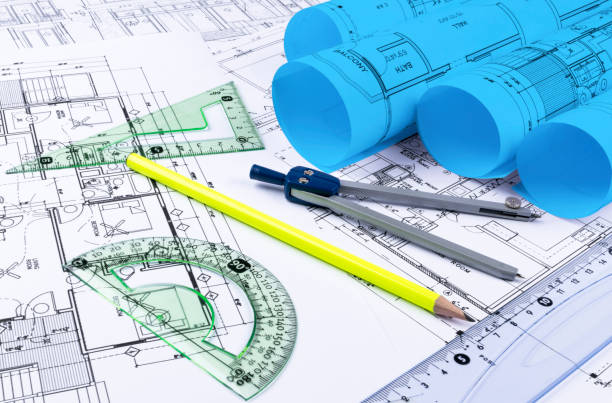 istock Architectural blueprints and blueprint rolls and a drawing instruments on the worktable. Drawing compass, plans. Civil Engineering, Construction background. 873008906