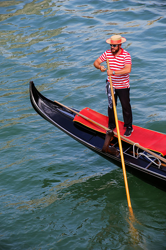Man rowing gondola in Venice, Italy. Venice is situated across a group of 117 small islands that are separated by canals and linked by bridges.