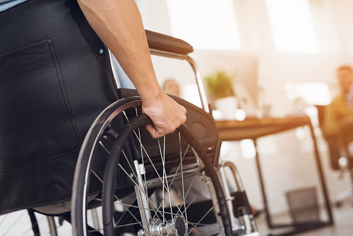 Un hombre discapacitado está sentado en una silla de ruedas. photo