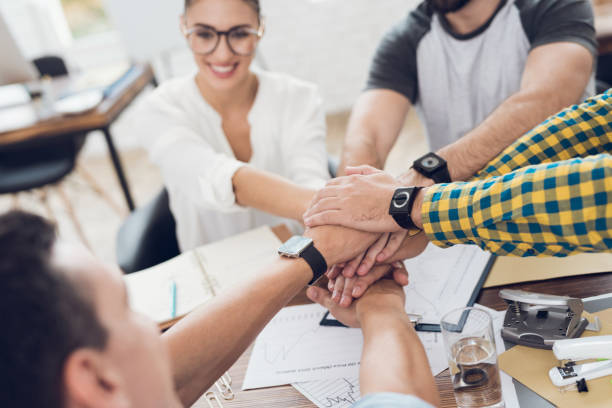 istock A group of young people discussing something in the office. They are showing a teamwork. 873016056