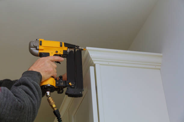 istock Carpenter brad using nail gun to Crown Moulding on kitchen cabinets 873022034
