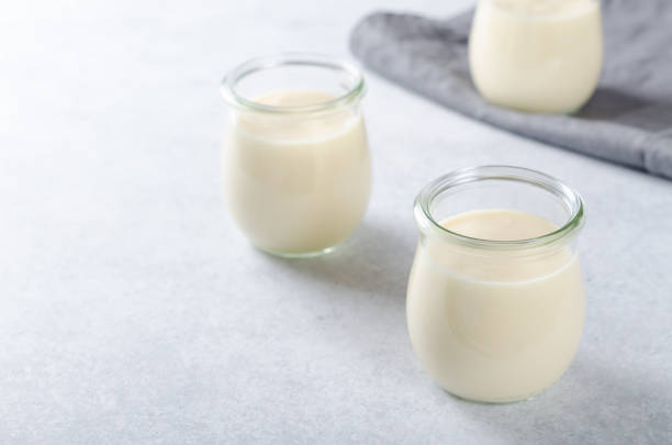 istock Lemon or vanilla curd in glass jars on a light stone table, sele 873025396