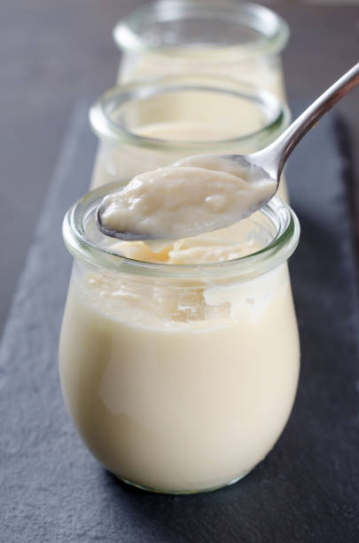 istock Lemon or vanilla curd in glass jars on a dark gray stone table, 873025568