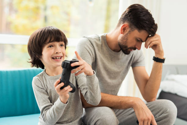 istock Father and son play together in computer games. 873028170