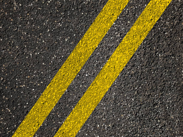 istock Yellow line on asphalt road background. 873030778