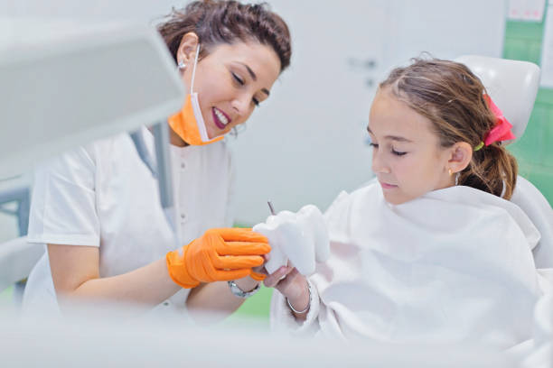 istock Dentist teaching happy girl about oral hygiene 873030920