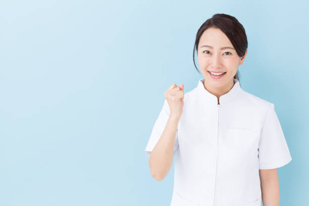 portrait von junge asiatische krankenschwester auf blauem hintergrund isoliert - orientale stock-fotos und bilder