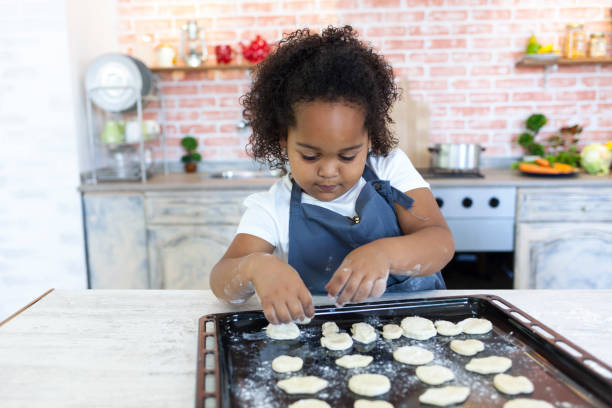 istock Cute little girl making biscuits at home 873055274