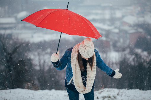 Woman with an umbrella standing in the snowy outdoors