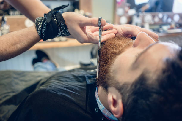 istock Close-up of the hand of a barber using scissors while trimming t 873068734