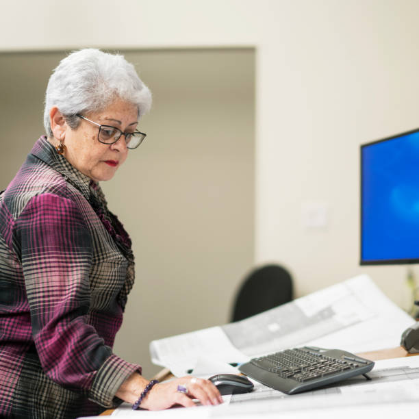 istock Senior silver-haired woman, engeneer, working with architectural project 873094966