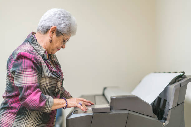 istock Senior silver-haired woman, engeneer, using the commercial wide format printer 873094984