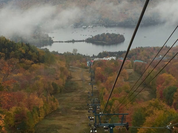 istock Gondolas climbing a mountain and view on a lake covert with fog 873098742