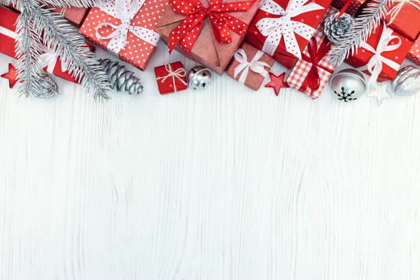 istock christmas red gift boxes, fir tree branches and silver decorations on wood background 873101086