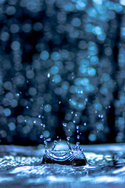 istock Water splash and wave, water drops and crown from falling into the water in light blue colors, on light Bokeh background 873103896