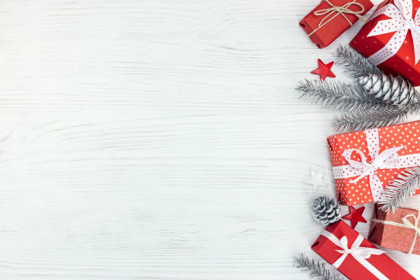 istock christmas red gift boxes, silver decorations, fir tree branches and cones background 873103980