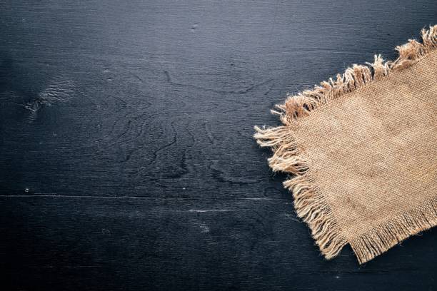 istock Old linen cloth on a black wooden background. Top view. Free space. 873107824