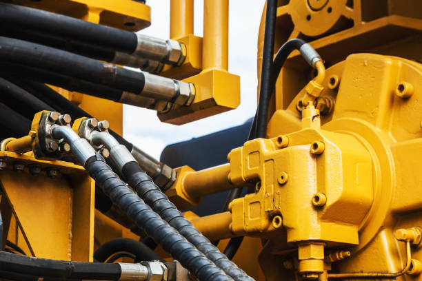 trattore idraulico giallo. concentrarsi sui tubi idraulici - hydraulic platform hose oil industry industry foto e immagini stock