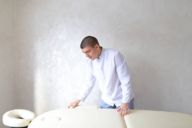 Professional male massage therapist preparing to receive patient
