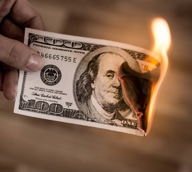 istock one hundred dollars burn in flames in hand 873131050