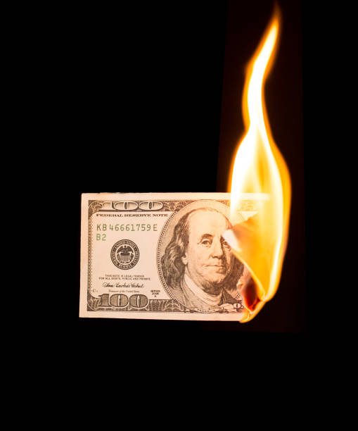 istock a hundred dollars burn in a fire on a black background 873131136