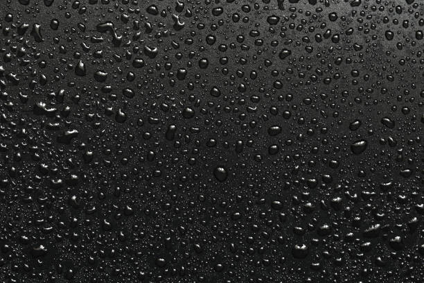 istock Drops of water on a black surface. The condensate. Top view. Free space. 873131708