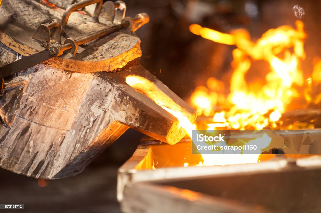 perator pouring molten metal in automatic casting line in foundry factory Operator pouring molten metal in automatic casting line in foundry factory, electric melting, high precision casting part manufacturing Foundry Stock Photo
