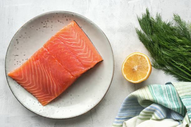 istock Fresh salmon steak, lemon and dill on concrete table. 873133730